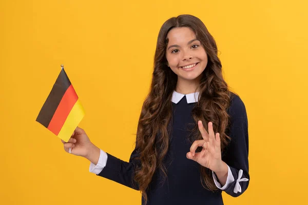Ok, gesto. bambino felice con la bandiera tedesca. visto turistico nel paese di schengen. — Foto Stock