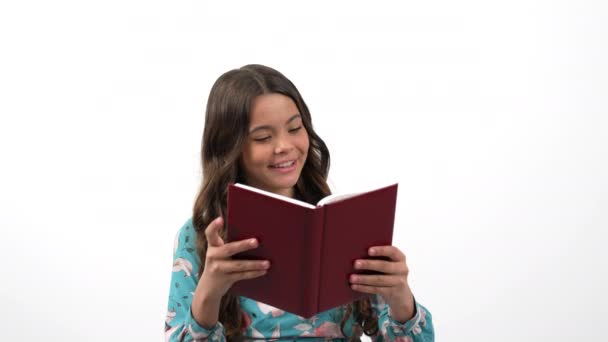 Mosolygós kíváncsi gyermek olvasó talál érdekes információkat elszigetelt fehér, iskola. — Stock videók