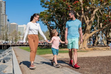 Arkadaş canlısı aile yazın eğleniyor. Mutlu ebeveynler çocuğu yönlendirir..
