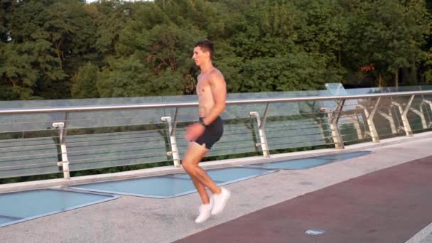 スポーツマンの男が真の高上昇で所定の位置にジョギング、動き — ストック動画