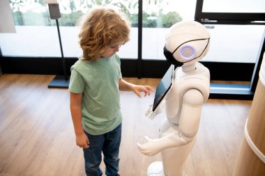 Robot çocuğa yardım sağlıyor. Otomasyon. Yapay zeka oğlanla etkileşim halinde