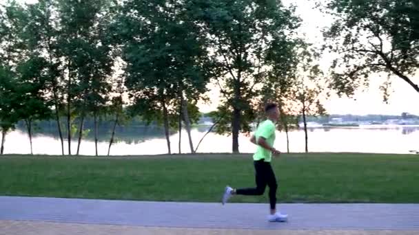 Sportiv sportiv în îmbrăcăminte sport care rulează la râu în aer liber, jogging — Videoclip de stoc