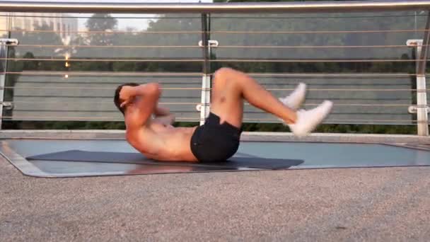 Atleta cara fazendo exercício de bicicleta para músculos abdominais ao ar livre, manter em forma — Vídeo de Stock