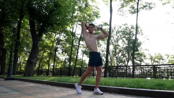 Fuerte muscular chico mostrando bíceps tríceps y los músculos del torso en la pose del culturista, el deporte culturismo — Vídeos de Stock