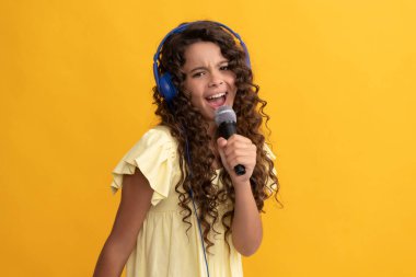 Yeni teknoloji. Çocukluk gelişimi. Çocuk şarkıcı mikrofonda karaoke söylüyor.