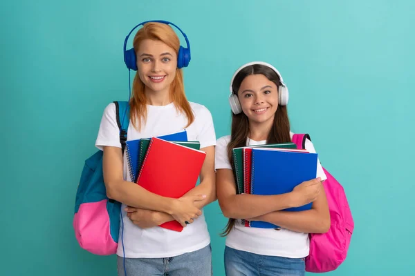 Anya és lánya fülhallgatóban tartja notebook és hátizsák készen áll a tanulásra, ebook — Stock Fotó