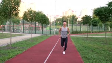 Spor eğitmeni parkta anaerobik yük eğitimi alıyor, sağlıklı bir yaşam tarzı.