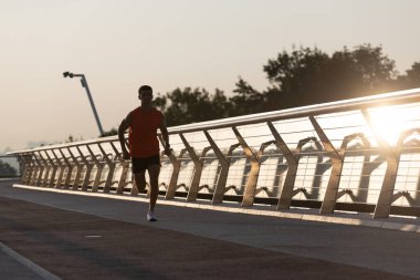 Atletik formda koşucu akşamları gezinti güvertesinde koşar.