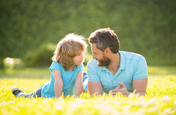 Valor familiar. infancia y paternidad. padre relajarse con niño pequeño en la hierba. — Foto de Stock