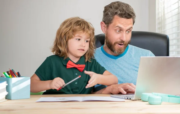 Asombrado padre e hijo en la escuela trabajando en línea en el ordenador portátil, asombro — Foto de Stock