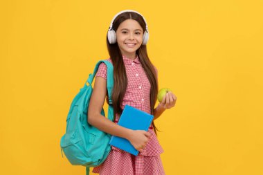 Eğitim konsepti. Öğlen yemeğinde iş kitabı ve elmalı kulaklıklı çocuk. Eylül 1.