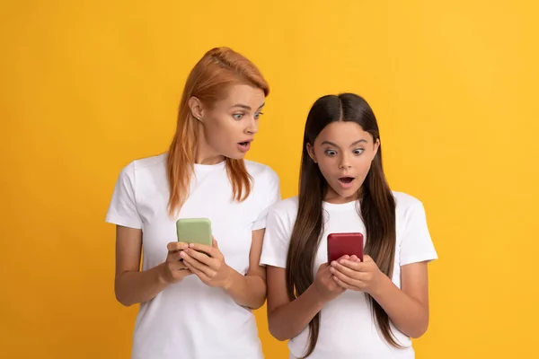 Förvånad mamma och barn flicka chatta online med modern smartphone, chatta — Stockfoto