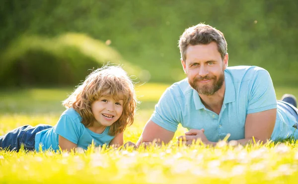 Feliz familia retrato de padre e hijo niño relajarse en el parque de verano hierba verde, verano relajarse — Foto de Stock