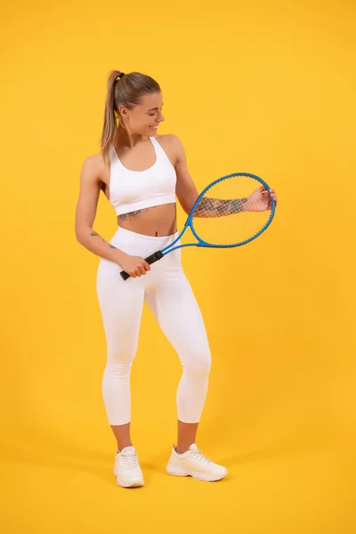 Idrottskvinna. sexig kvinna med racket på gul bakgrund. kvinnlig tennisspelare. — Stockfoto