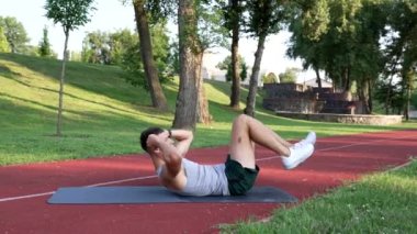 Atletik antrenör dışarıda bisiklet egzersizi ve enerjiyle karnımı güçlendiriyor.