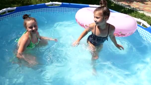 Счастливые девушки плавают в открытом бассейне в солнечный летний день, купаются — стоковое видео