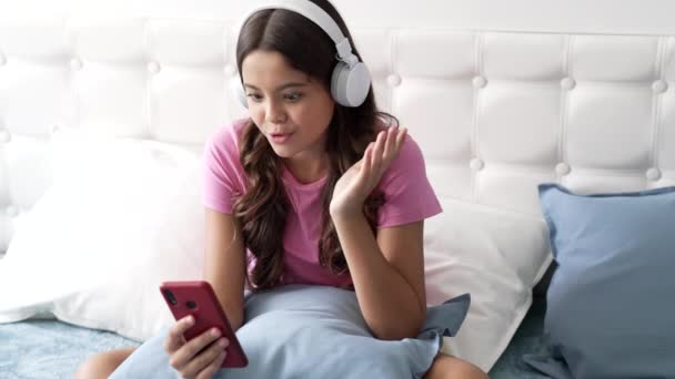 Niño emocional en los auriculares que tienen conversación en línea usando el teléfono celular, blogging — Vídeo de stock