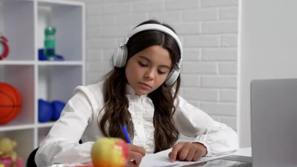 Grave bambino in cuffia scrivere dettatura a scuola lezione online con computer portatile, studio di quarantena — Video Stock