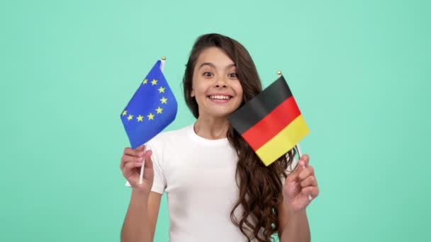 Kind mit glücklichem Gesicht schwenkt europäische Union und deutsche Fahne, selektiver Fokus, Fußballfan — Stockvideo