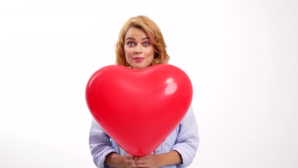 Gaie dame montrant la langue derrière ballon coeur, chérie — Video