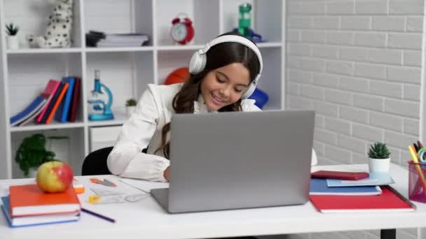Glad unge i hörlurar avslutade online utbildning på datorn och används smartphone, skola. — Stockvideo