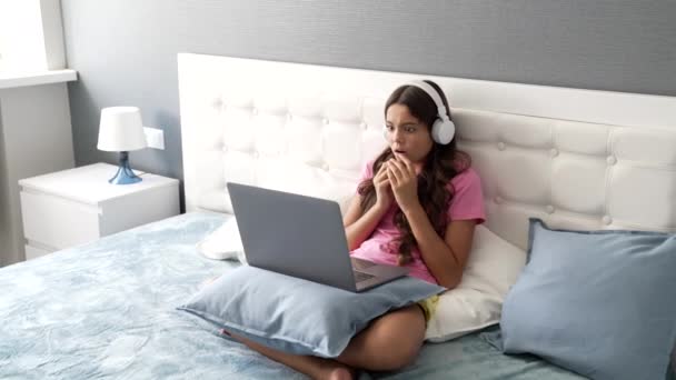 Niño preocupado en los auriculares con la cara sorprendida esperando el resultado de la lección mirando en el ordenador, día de inicio — Vídeo de stock