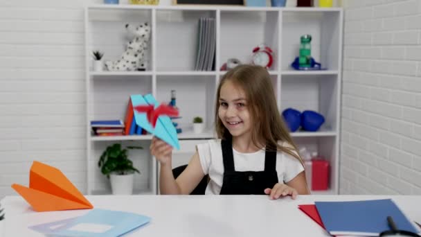 Niño feliz que se divierte jugando con avión de papel en la escuela lección en el aula, tiempo de la escuela — Vídeos de Stock