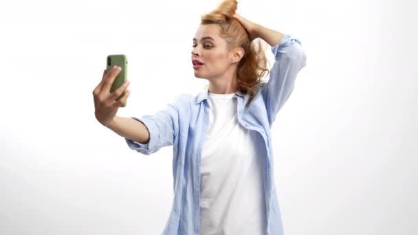 Mosolygós nő megérinti a haját előtt mobiltelefon kamera, szelfi videó — Stock videók