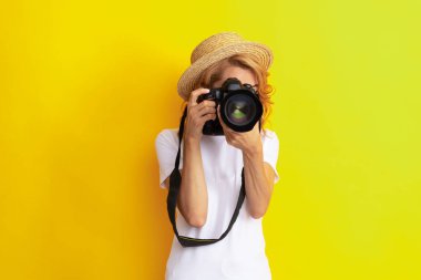 Hasır şapkalı kadın fotoğrafçı fotoğraf çekiyor, lens yapıyor.