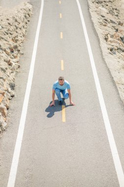 Olgun bir adam yola koyuluyor Koşmaya hazır, koşucu