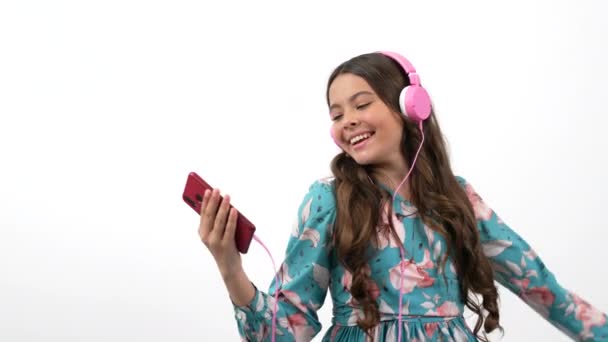 Allegra danza bambino tenere il telefono cellulare ascoltare musica in cuffia con gesto di pace, amante della musica — Video Stock