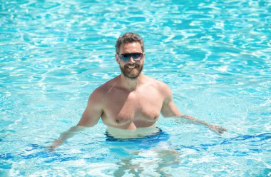 Yaz havası konsepti. Yaz tatili. Adam suya gözlük takıyor..