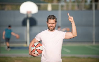 Basketbol topu olan kaslı bir adam. Spor antrenörü ya da basketbol oyuncusu. spor okulu.