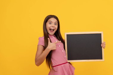 Hayretler içindeki çocuk kopya alanı için okul karatahtasını tutuyor başparmağını gösteriyor, anons ediyor.