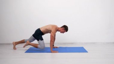 Kas sporcusu dağcılık egzersizi yapıyor fitness minderi üzerinde, ısınma egzersizi yapıyor