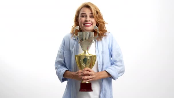 Menina feliz surpresa comemorar o sucesso com copo do campeonato, prêmio de realização — Vídeo de Stock