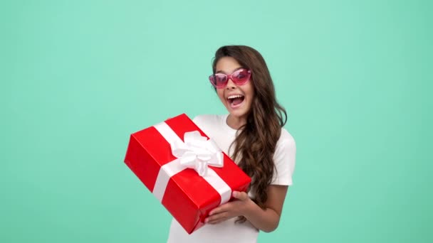 Glücklich überraschtes Kind in Sonnenbrille hält Geschenkbox, Einkauf — Stockvideo