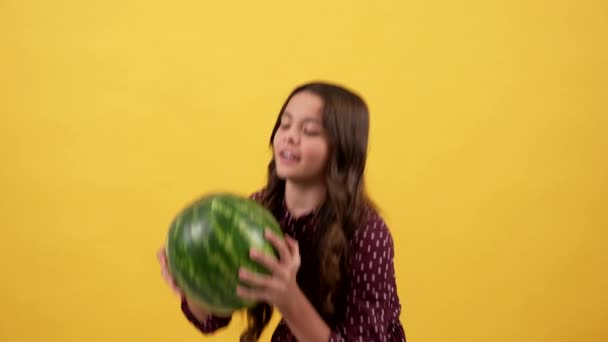 Amazed kid taking heavy water-melon fruit on yellow background, fruit — Stock Video