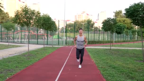 Jovem cara esportista jogging ao ar livre, treinamento esportivo — Vídeo de Stock