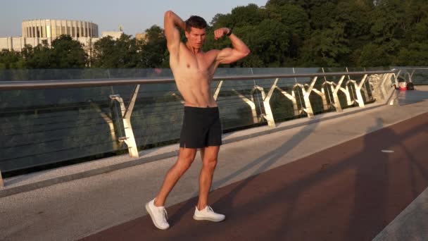 Bíceps musculación pose de joven musculoso culturista con cuerpo en forma, músculos — Vídeos de Stock