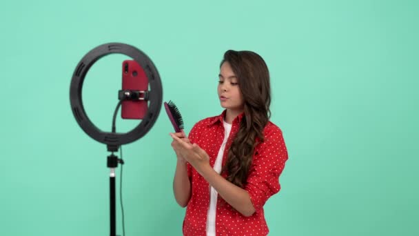 Dítě krása blogger kartáčování její dlouhé kudrnaté vlasy s hřebenem, vypadávání vlasů koncept — Stock video