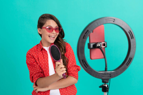 счастливый ребенок представляет расческу в солнцезащитных очках в блоге, реклама.