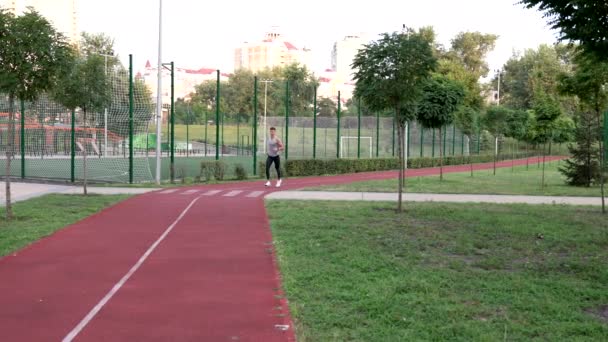 Formda vücut sporcusu parkta koşuyor, sprinter. — Stok video