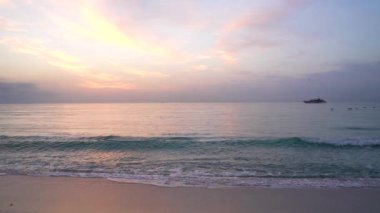 Kuşların gökyüzünde uçtuğu ve ufukta gemi parladığı güzel gün doğumu deniz manzarası.