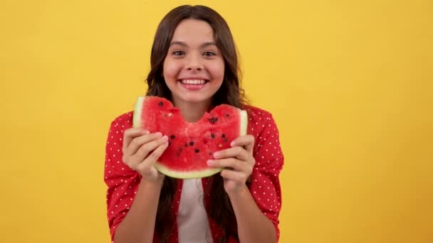 Surprised hungry kid eating slice of water-melon fruit on yellow background, watermelon — Stock Video