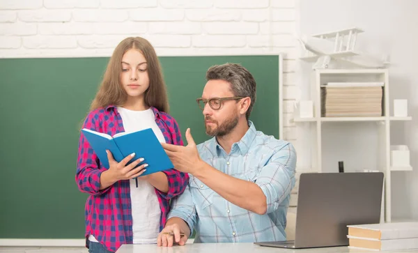 Vater und Tochter nutzen Notizbuch. zurück zur Schule. Kindererziehung. Konzentrierter Schüler und Tutor — Stockfoto