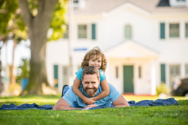 행복 한 아버지가자녀 와 함께 푸른 공원 잔디 위에서 휴식을 취하는 것, 친구들 — 스톡 사진
