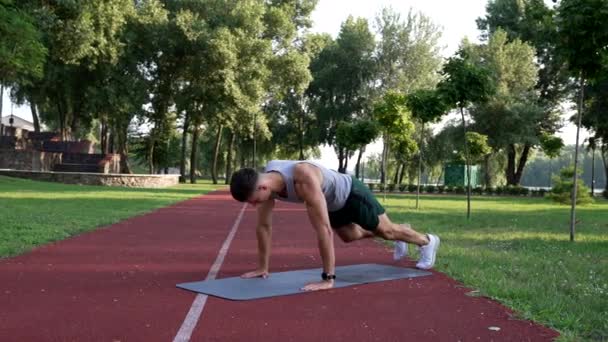 Sportivo che lavora sui suoi sei pacchetti con esercizio di montagna rocciosa sul tappeto fitness all'aperto, sportivo — Video Stock