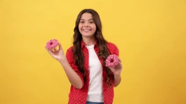 Mutlu çocuk donutu sarı arka planda, çocuklukta