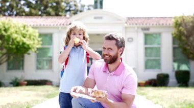Okulda yemek yiyen çocuk ve babadan oluşan mutlu bir aile, yavaş çekim, aile